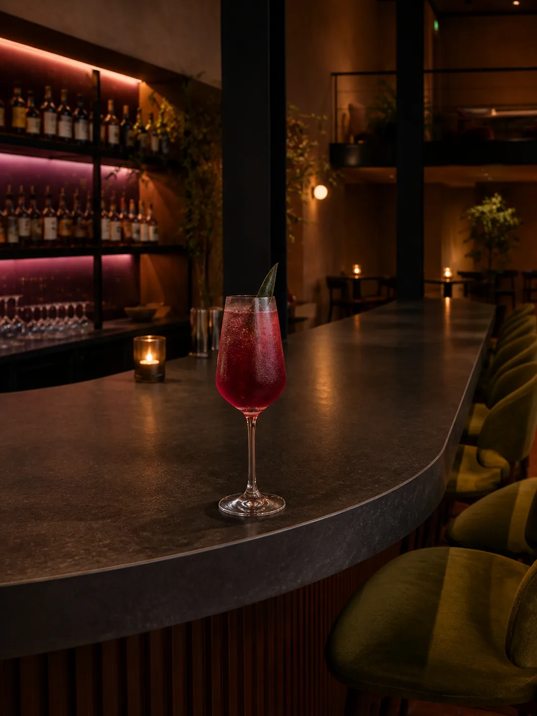 The ruby-plum Afterlight non-alcoholic drink on the curved bar.